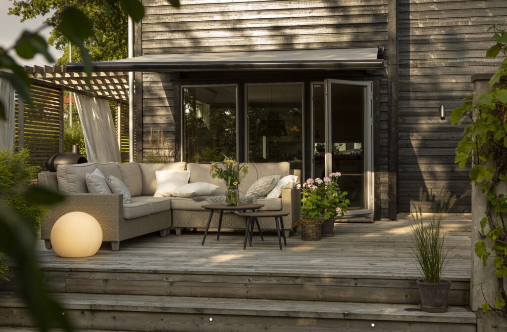 Grå terrassmarkis över uteplats.