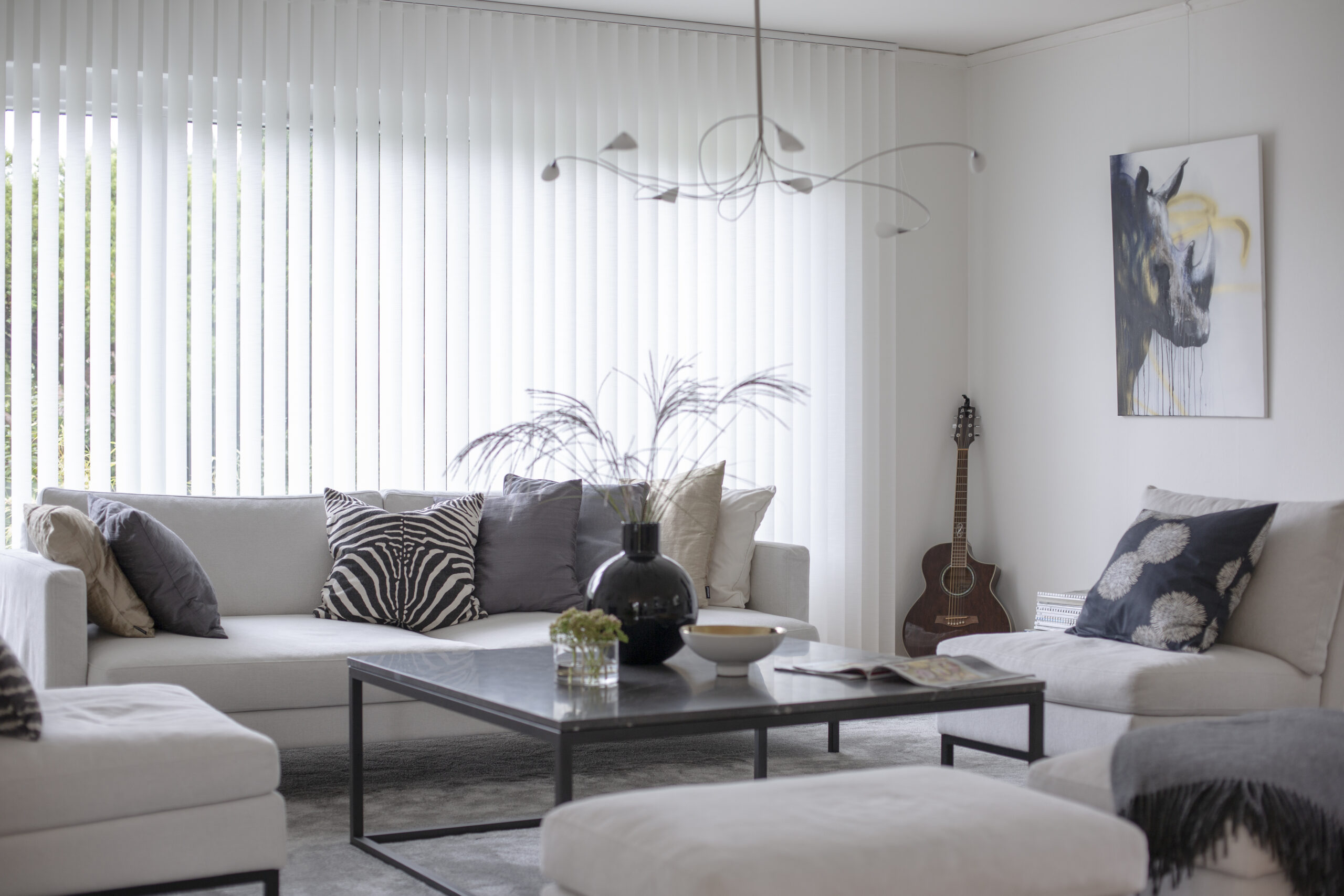 Vit lamellgardin i vardagsrum.