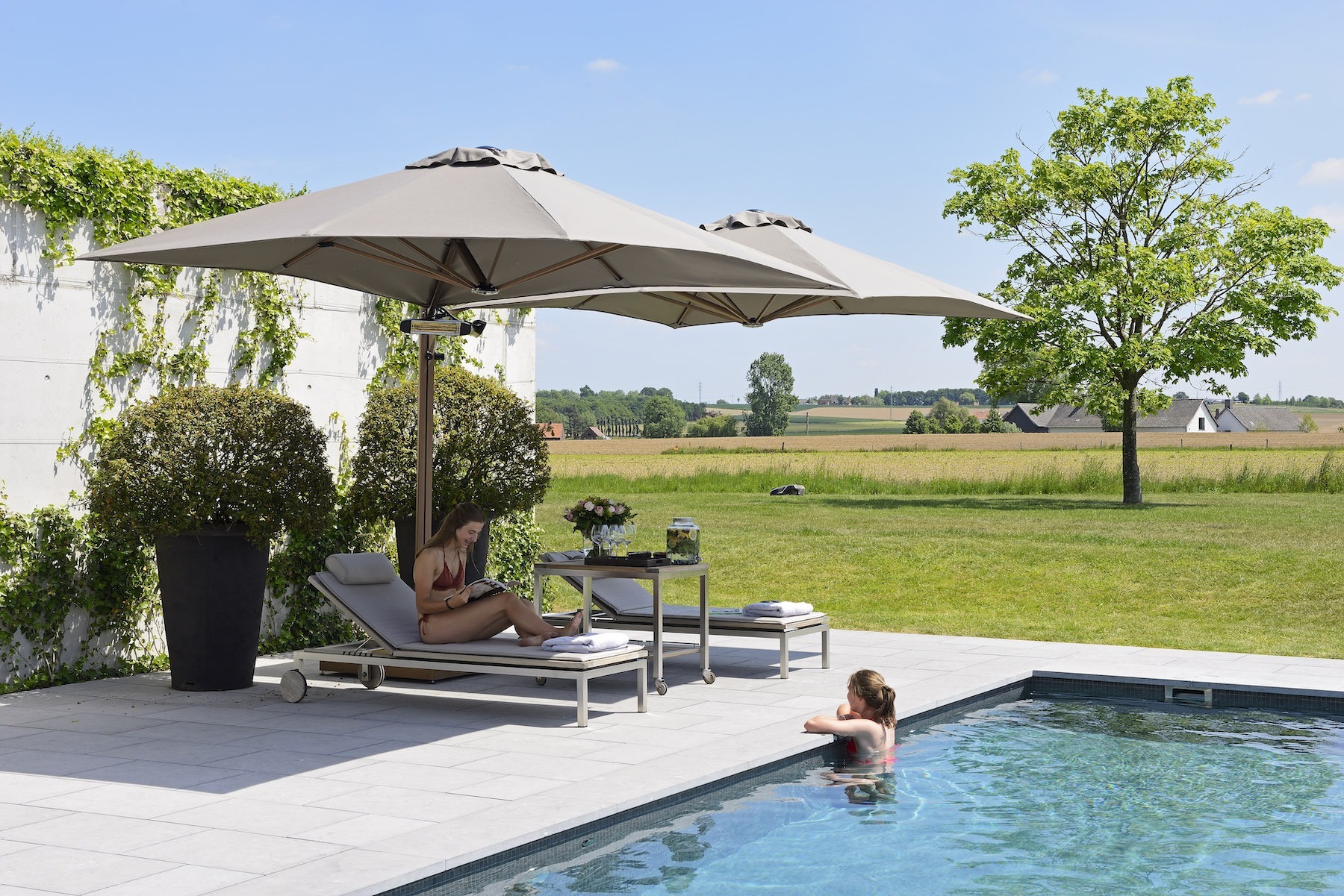 Två parasoll på en stolpe vid pool.