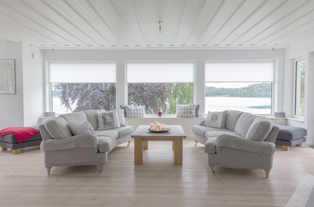 Vita plissegardiner i vardagsrum.