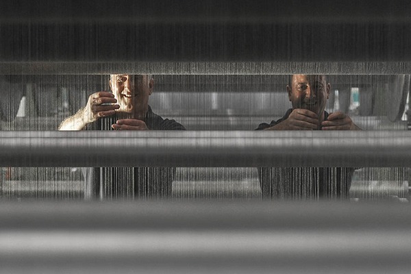 Kontrollering av trådar på vävfabrik.