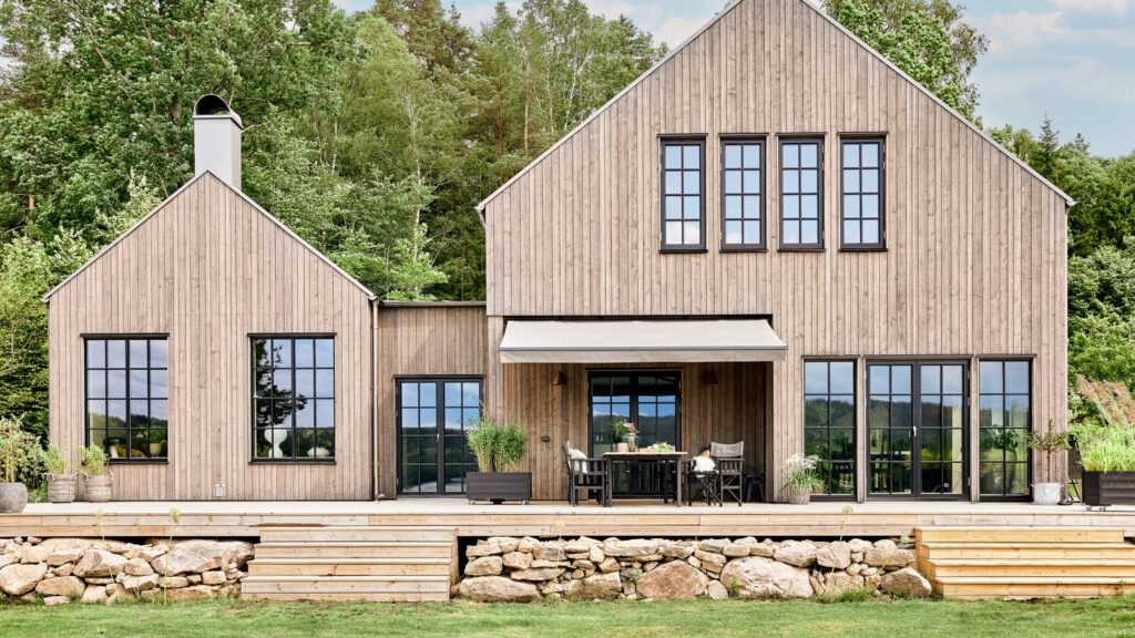 Terrassmarkis på villa med träfasad.