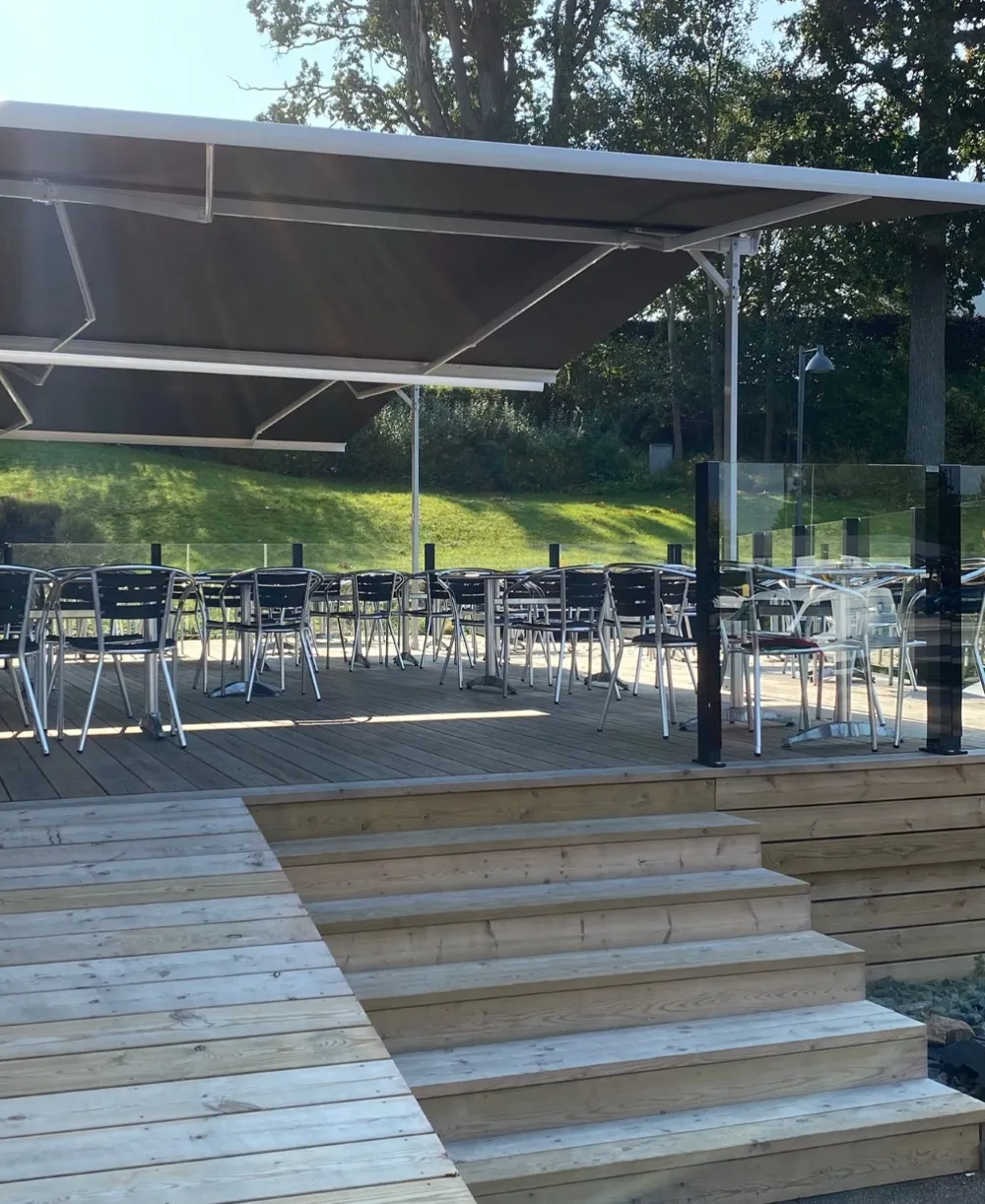 Fristående markis över uteservering med glasräcke runt om