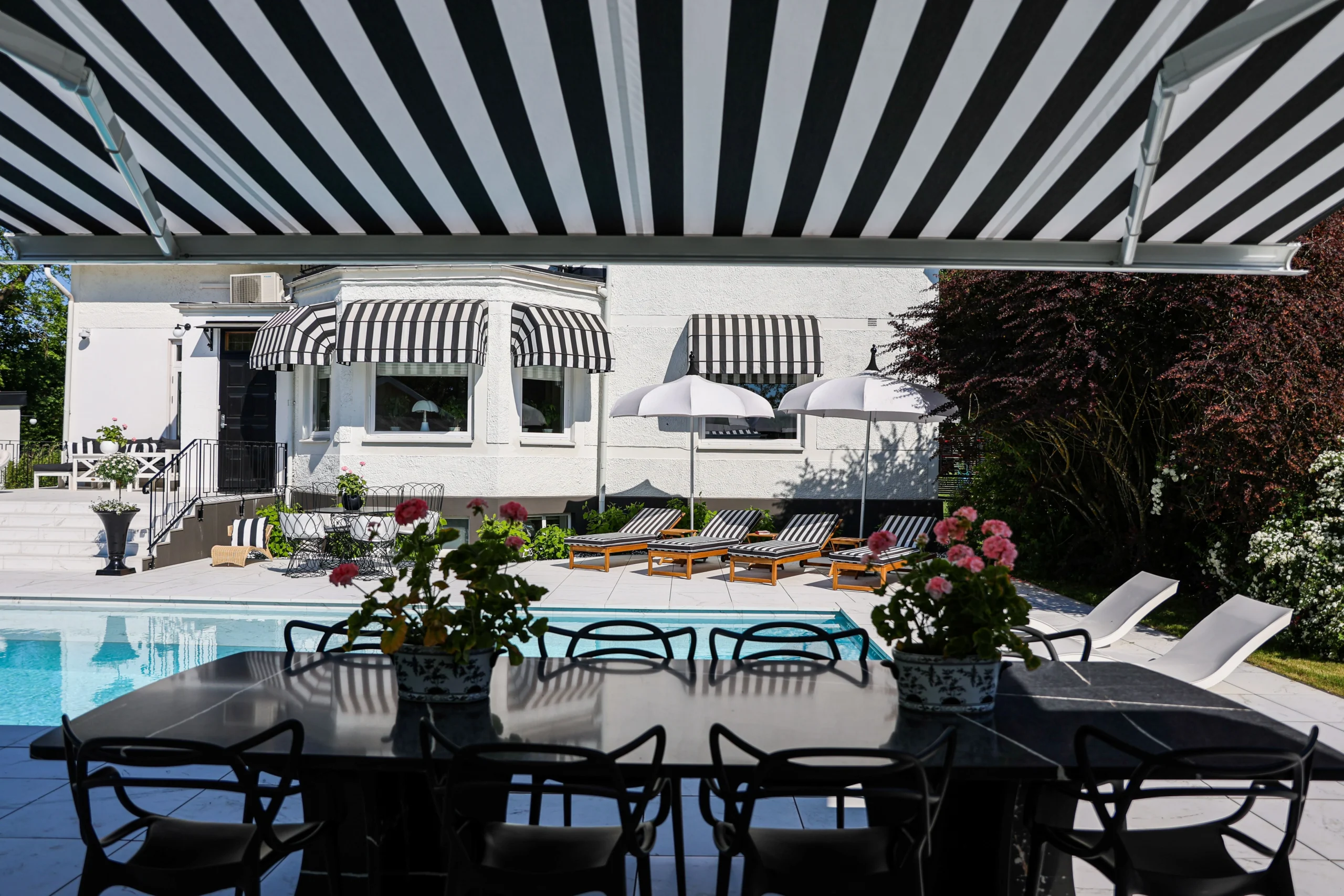 Terrassmarkis och korgmarkiser med svart/vit randig väv.