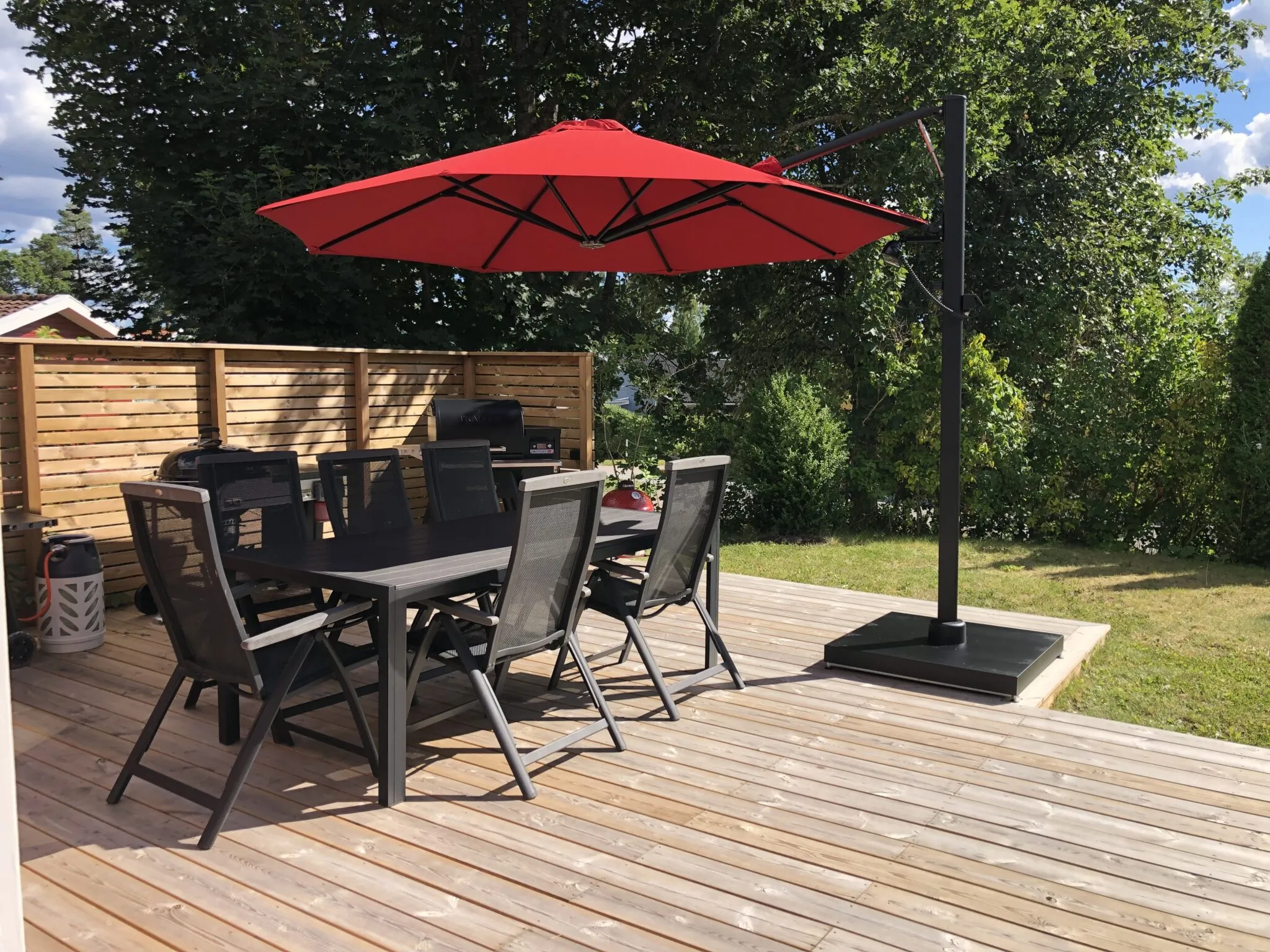 Rött parasoll på altan.