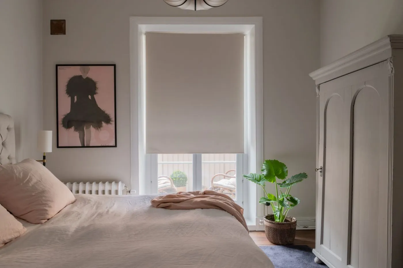 Vit mörkläggande rullgardin i sovrum.