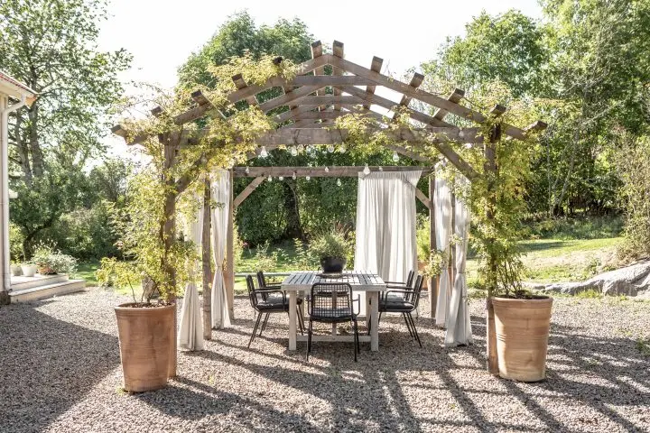 Utomhusgardiner i träpergola.