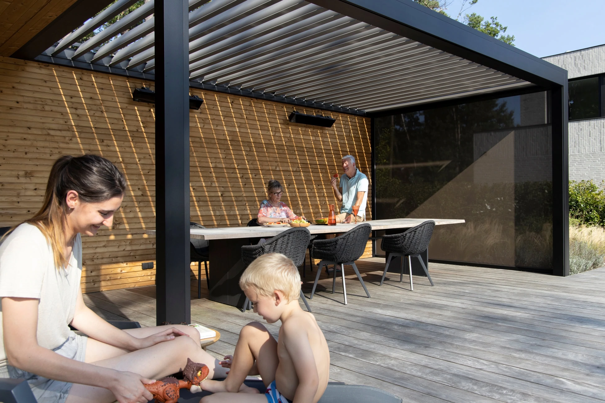 Svart pergola med lamelltak.