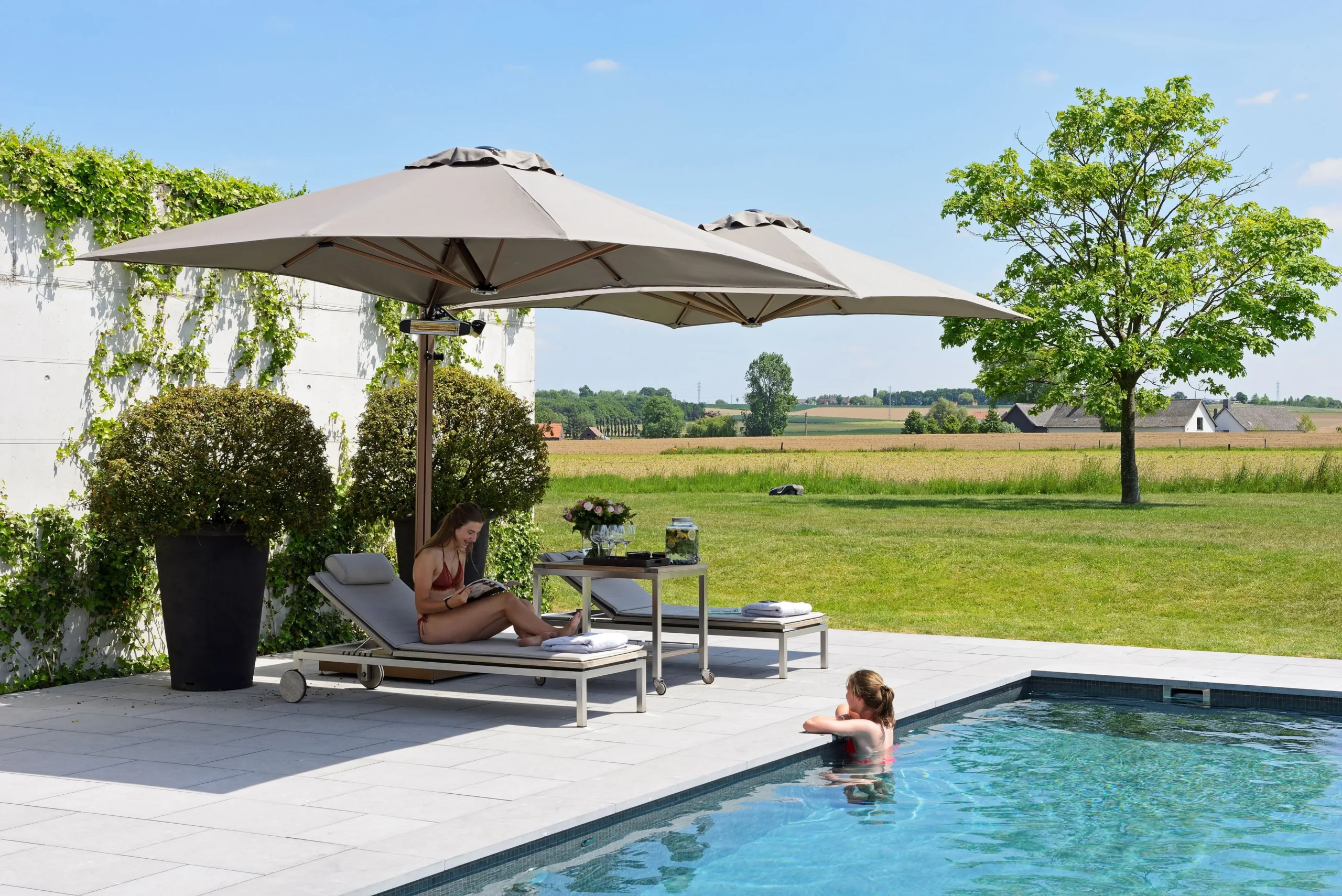 Två parasoll på en stolpe vid pool.