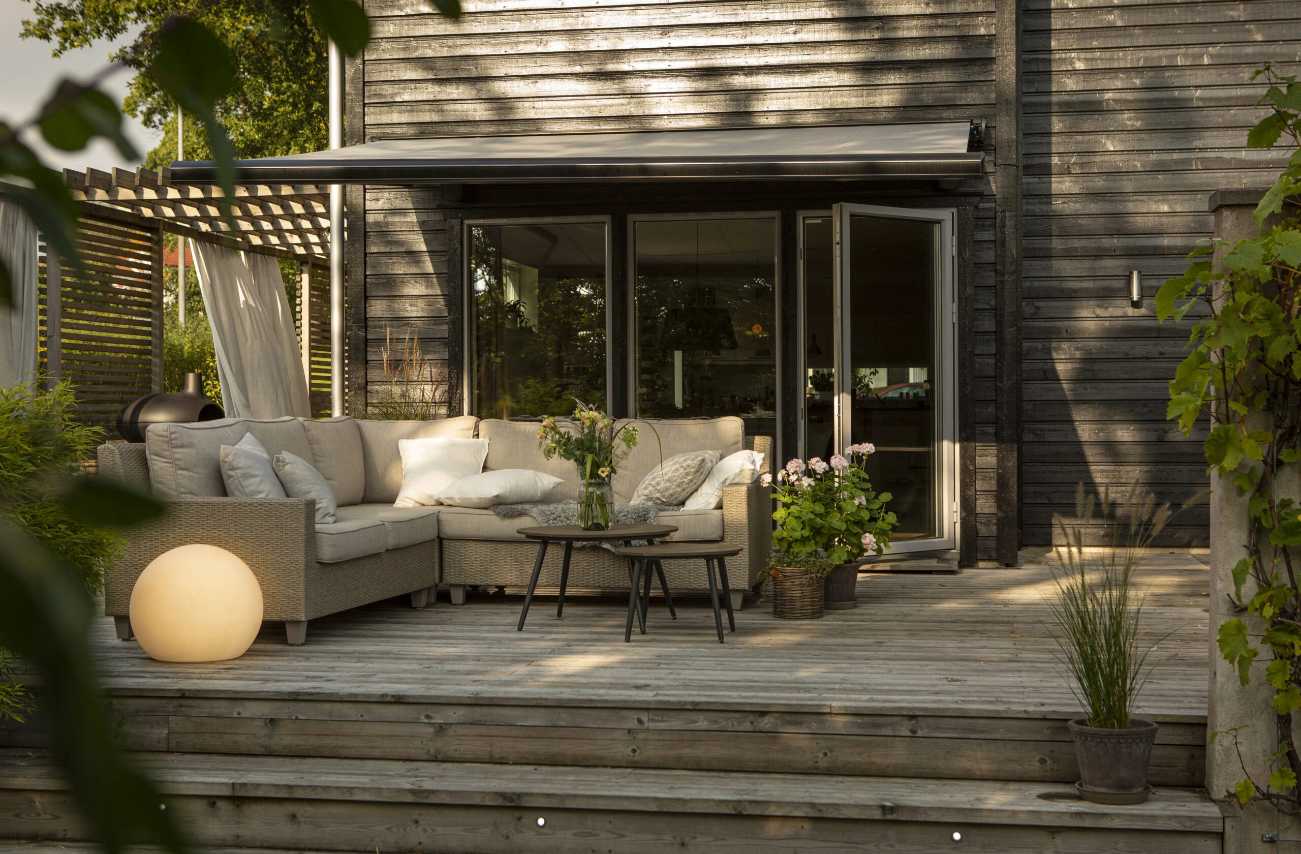 Grå terrassmarkis över uteplats.